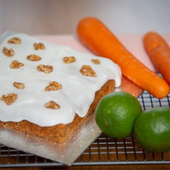 Carrot cake with its ingredients, carrots, and limes